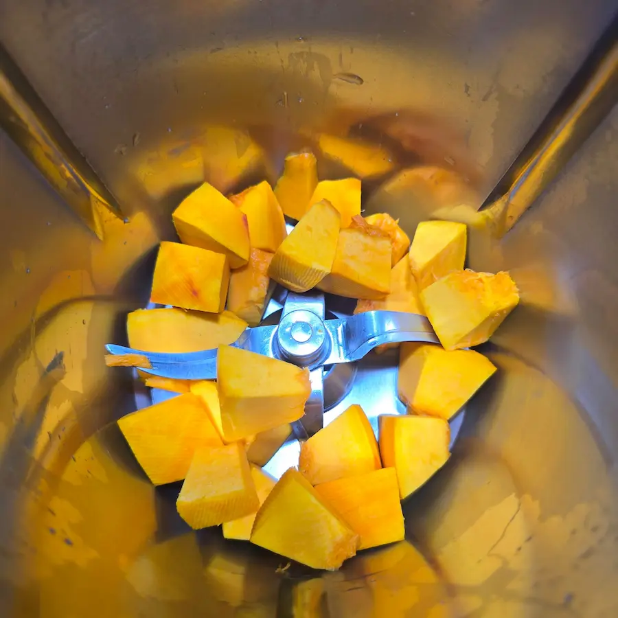 Pokrojona dynia Hokkaido w naczyniu miksującym Thermomix przed rozdrobnieniem