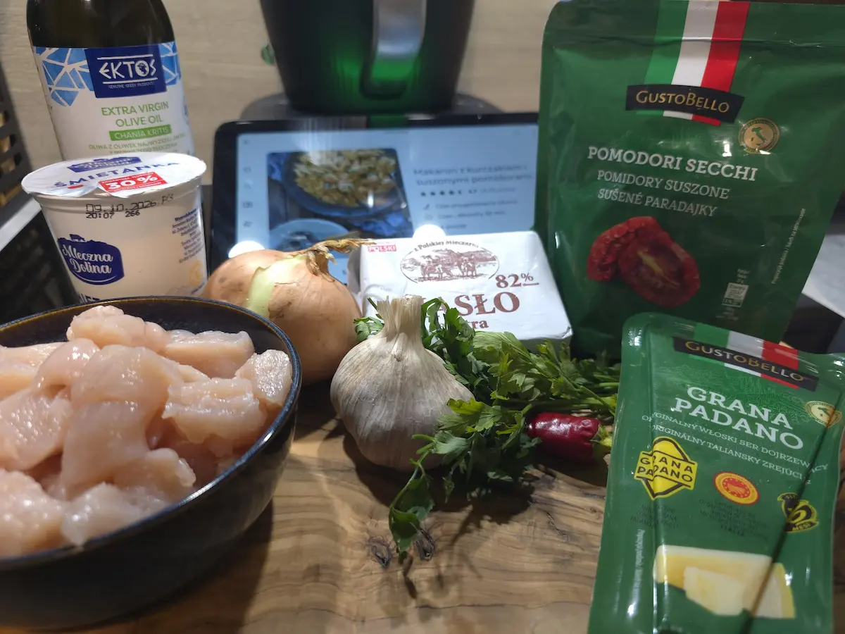 Składniki na makaron z kurczakiem i suszonymi pomidorami: filet z kurczaka, śmietanka, cebula, czosnek, zioła, masło i ser