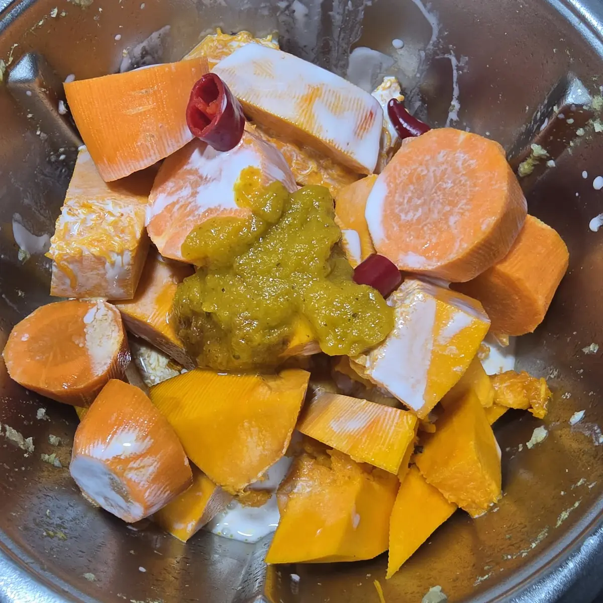 Kawałki dyni Hokkaido i marchewki z mleczkiem kokosowym oraz przyprawami w naczyniu Thermomix